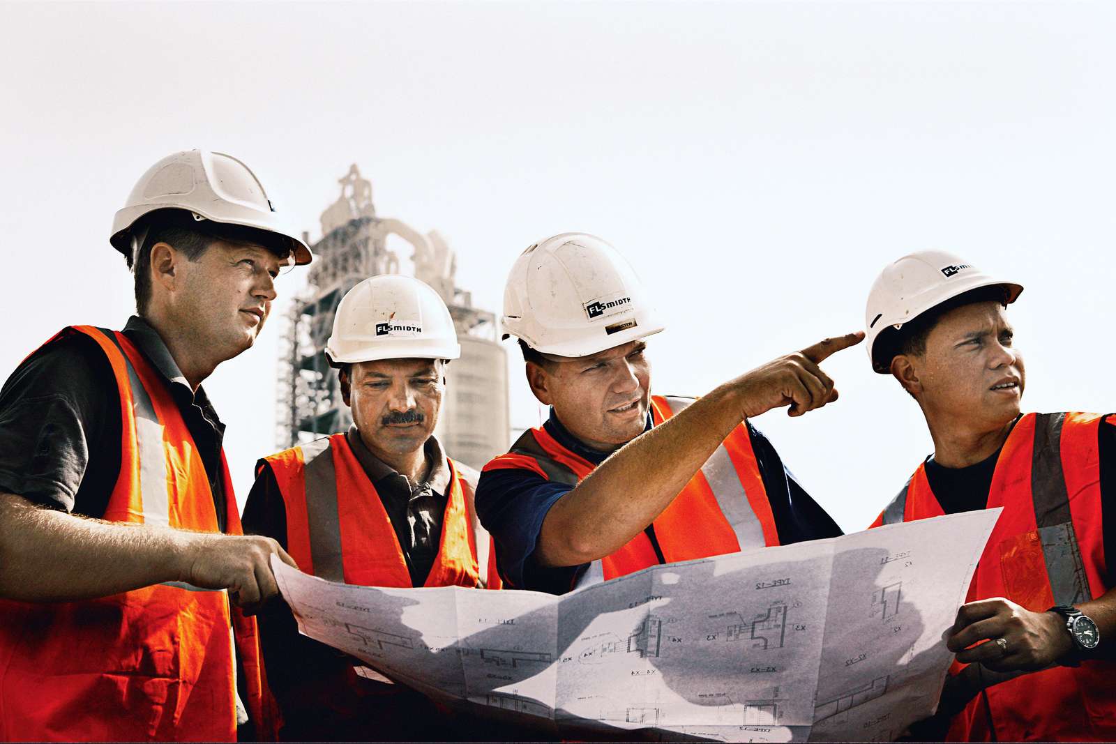 FLSmidth engineers inspecting construction plans on-site at a cement plant